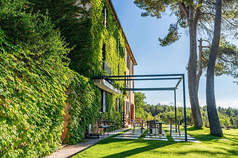 Ivy-covered retreat house exterior with garden seating at MasQi Energy House Spain
