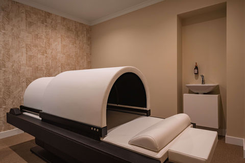 Infrared therapy room with sleek design and curved treatment bed.