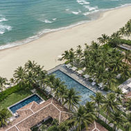 Aerial view of the beachfront pool and villas at TIA Wellness Resort in Da Nang, Vietnam
