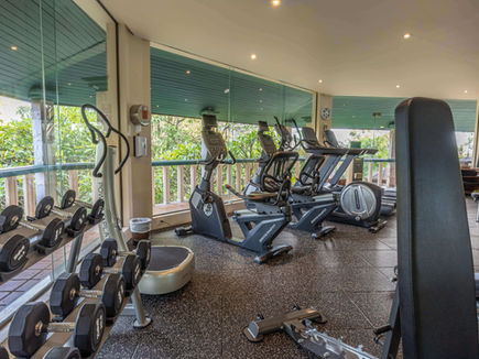Modern fitness centre with cardio and strength equipment at Mangosteen Resort