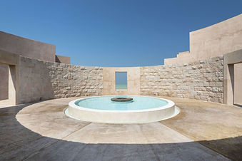 Circular stone water feature with sea view at Zulal Wellness Resort