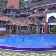 Outdoor swimming pool at Ayursoma Kerala, surrounded by heritage-style accommodation.