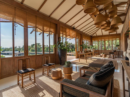 Pavilion lounge at RAKxa with woven pendant lighting and full-height lake windows