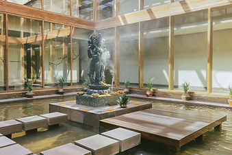 Tranquil courtyard with a water feature and statue at Six Senses Vana wellness retreat in Dehradun, India.