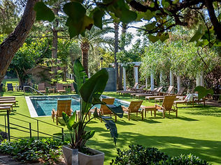 Outdoor pool with garden and seating area at Palasiet Thalasso Wellness Retreat