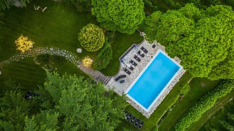 Aerial view of outdoor pool surrounded by lush garden at Villa Eden in Merano