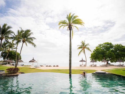 Infinity pool at Shanti Maurice with palms and the lagoon beyond