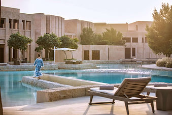 Guest relaxing by the outdoor pool at Zulal Wellness Resort