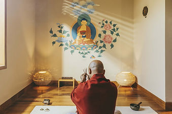 Meditation session led by a monk in a peaceful room at Six Senses Vana wellness retreat.