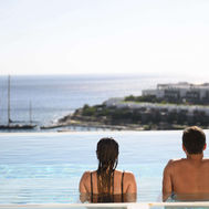 Couple enjoying the infinity pool at Porto Elounda Resort Crete