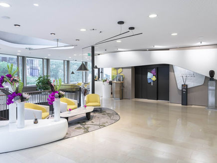 Reception lounge at Clinique La Prairie with curved seating and garden views