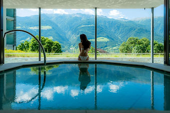 Indoor pool with panoramic mountain views at Preidlhof in South Tyrol