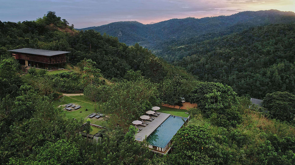 Remote hillside view of Santani Wellness Resort in Sri Lanka with forested mountains, open-air villas, and hillside pool.
