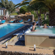 Guests relaxing in the outdoor hot tub beside the pool at Azulfit Wellness Retreat, Spain