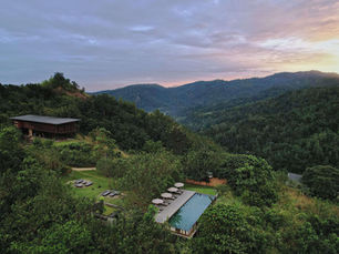 Aerial view of Santani Wellness Resort in Sri Lanka surrounded by lush green hills and an outdoor pool.
