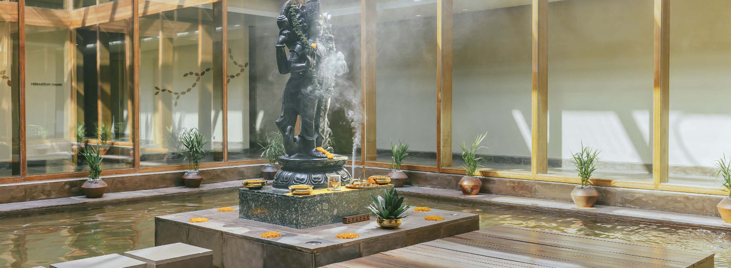 Tranquil courtyard with water feature and statue at Six Senses Vana retreat in India