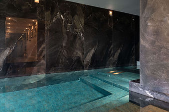 Indoor hydrotherapy and vitality pool with dark stone walls