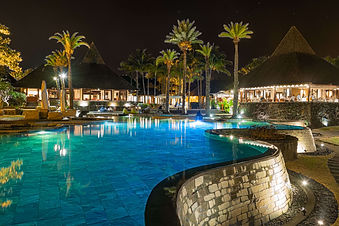 Evening pool area lit up under palm trees at Shanti Maurice Resort & Spa Mauritius