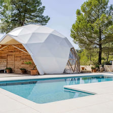Geodesic dome and outdoor pool surrounded by pine trees at MasQi, The Energy House in rural Spain