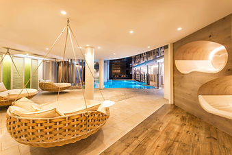 Preidlhof spa relaxation area with hanging loungers and indoor pool in South Tyrol, Italy