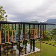 Glass-walled restaurant pavilion seen from the lawn outside