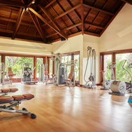 Gym at Shanti Maurice with cardio and resistance equipment beneath a vaulted timber ceiling