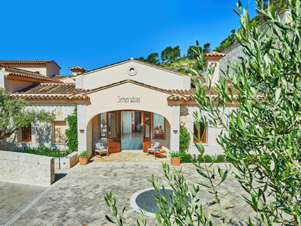 Entrance to Serenitas Spa at Cap Vermell Grand Hotel, framed by olive branches