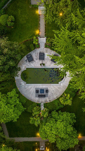 Aerial view of the circular garden pond and surrounding greenery at Villa Eden Wellness Retreat in Merano, Italy