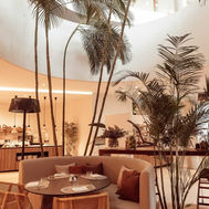 Bite buffet restaurant at Domes Baobab Suites, with palms beneath a curved atrium