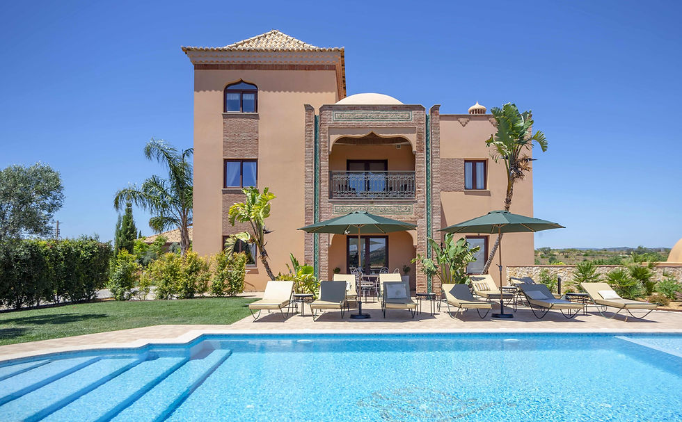 Exterior view of Al Karob Boutique Hotel with pool and sun loungers in Algarve, Portugal