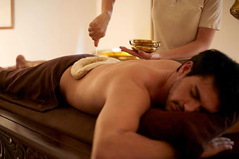 Warm oil poured during a traditional massage on the RAKxa Rebalance programme, Thailand
