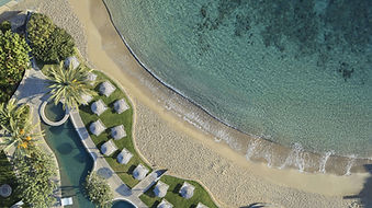 Aerial view of Porto Elounda Resort private sandy beach with sun loungers in Crete Greece