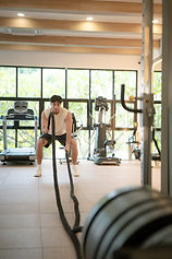 Man training with battle ropes in the fitness centre at Absolute Sanctuary, Koh Samui