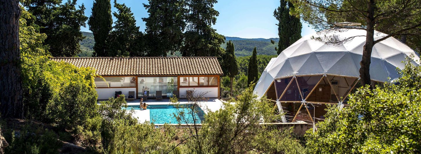 Wellness dome and pool surrounded by pine trees at MasQi Energy House Spain