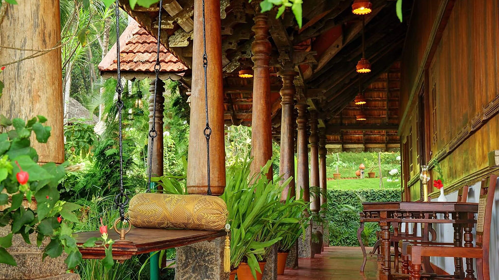 Wooden veranda with traditional pillars and lush tropical plants at Somatheeram Ayurveda Village in Kerala.