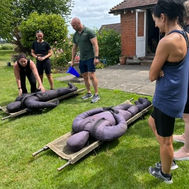 Women preparing for a strength exercise using weight-filled sandbags at GI Jane Bootcamp.
