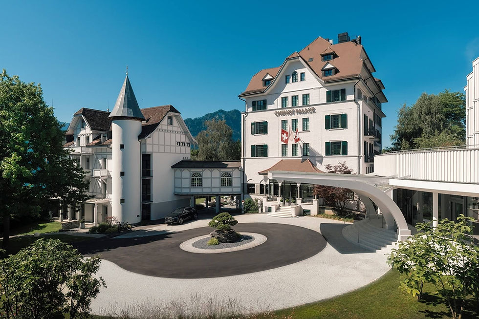 Exterior view of Chenot Palace Weggis showing historic building, modern wellness wing, and main entrance with a circular driveway
