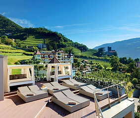 Preidlhof wellness resort terrace with daybeds overlooking the vineyards and mountains in South Tyrol, Italy