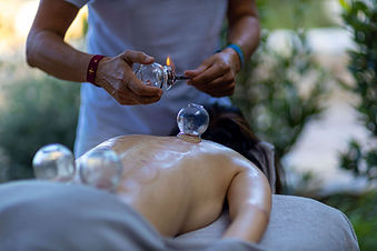 Traditional cupping massage therapy in a serene outdoor setting
