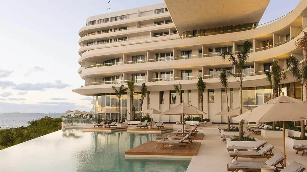 Infinity pool at SHA Wellness Clinic in Mexico surrounded by elegant sun loungers and parasols, set against a serene ocean backdrop.