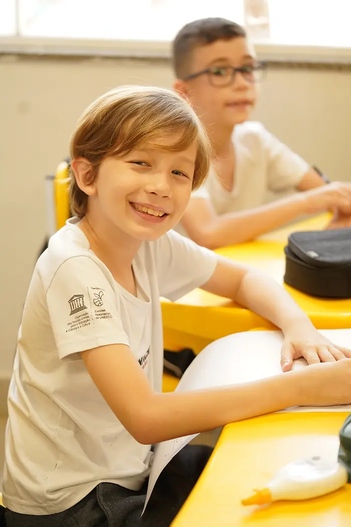 Aluno sorrindo durante uma atividade em sala