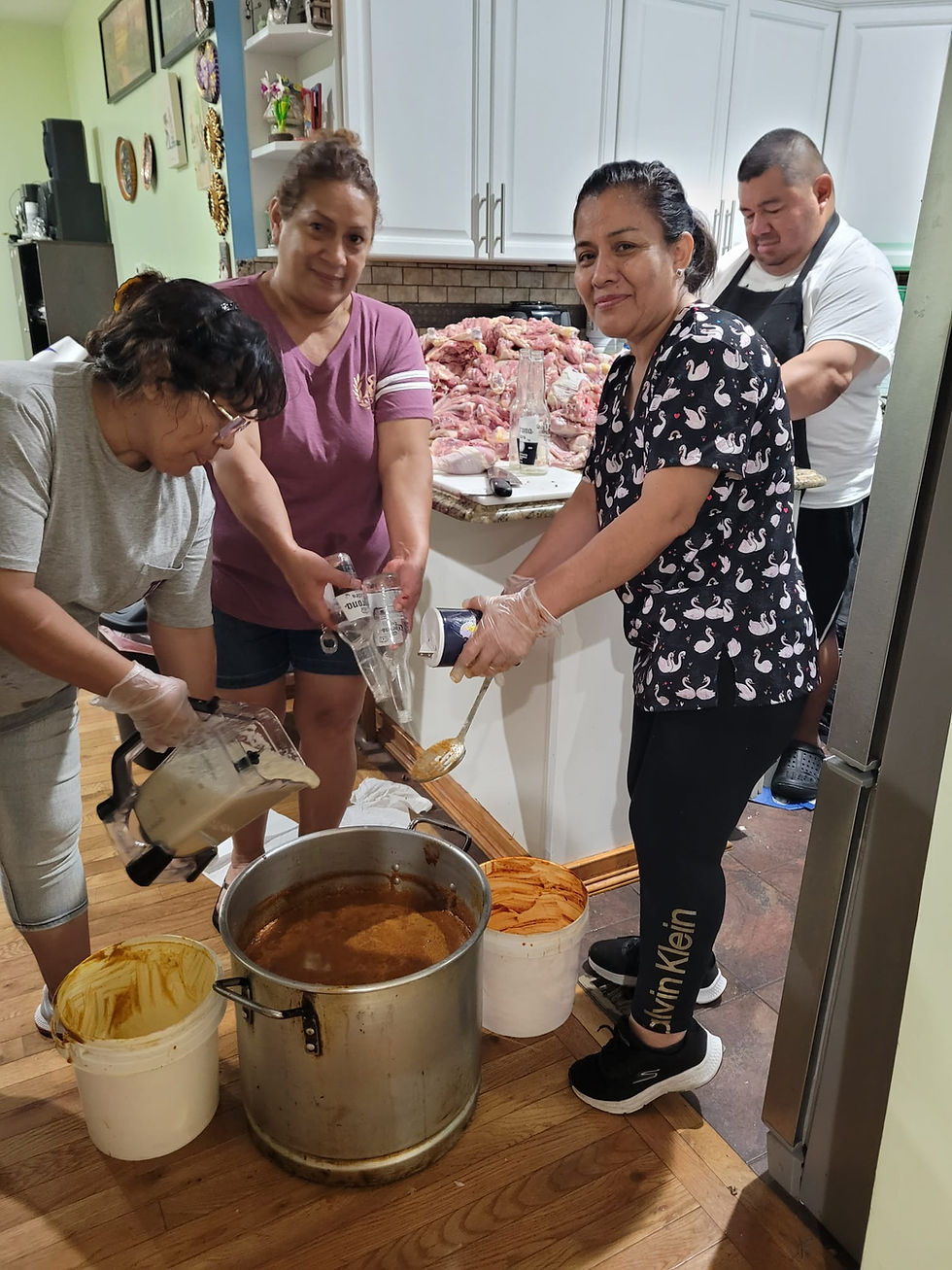 Volunteers cooking a large pot of food for the Project South America community cookout