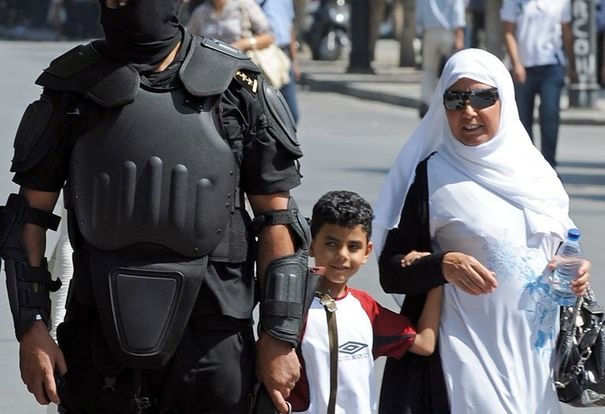 445700_une-tunisienne-et-son-fils-passent-a-proximite-d-un-policier-le-21-septem