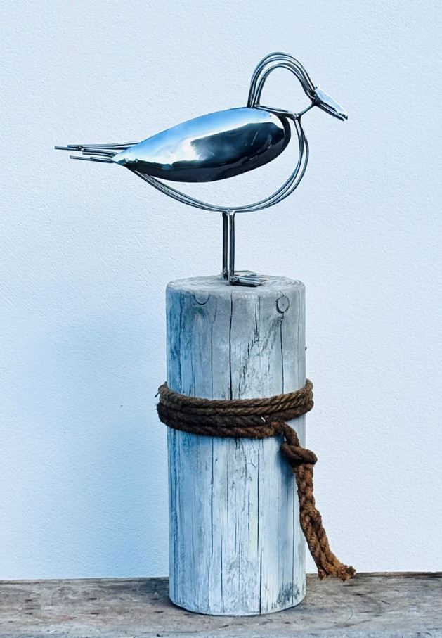 sculpture using repurposed materials of a seagull standing on a mooring post