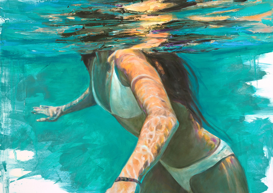 Woman in white bikini swims underwater, light refracting through the water