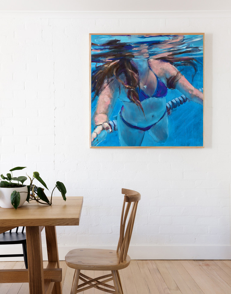 painting of a young woman floating effortlessly in the water, arms outstretched. Painting hanging in a dining room