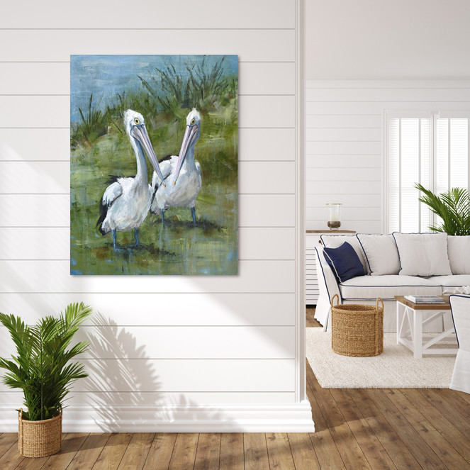 Large A0 pelican canvas print in a dark oak frame styled as a focal point in a coastal home.