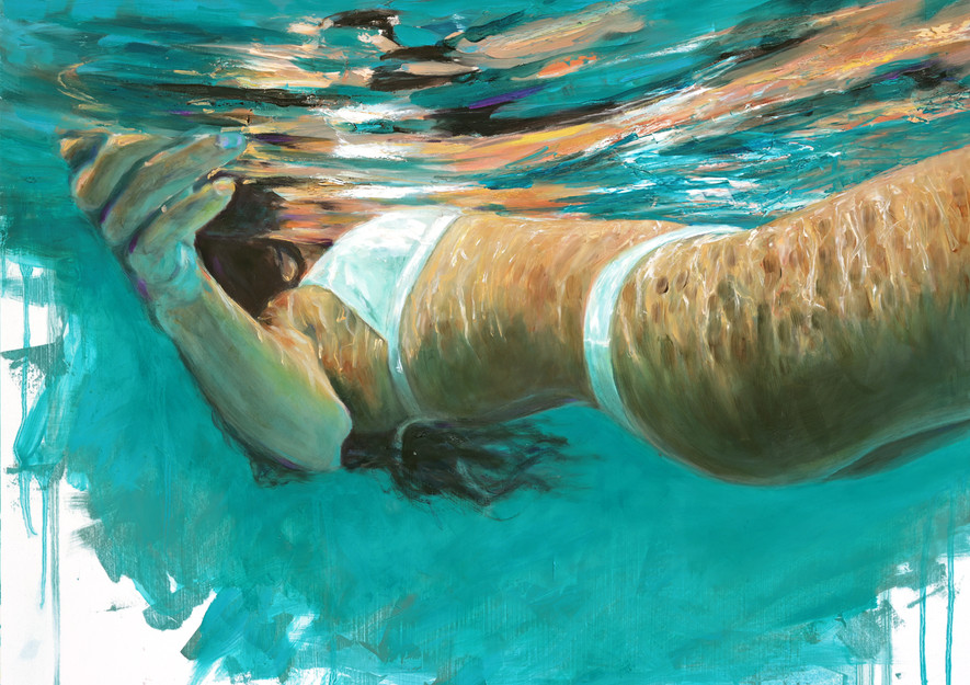 Woman submerged in blue water, wearing a white bikini top and bottoms