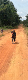 Two children walking down a road.