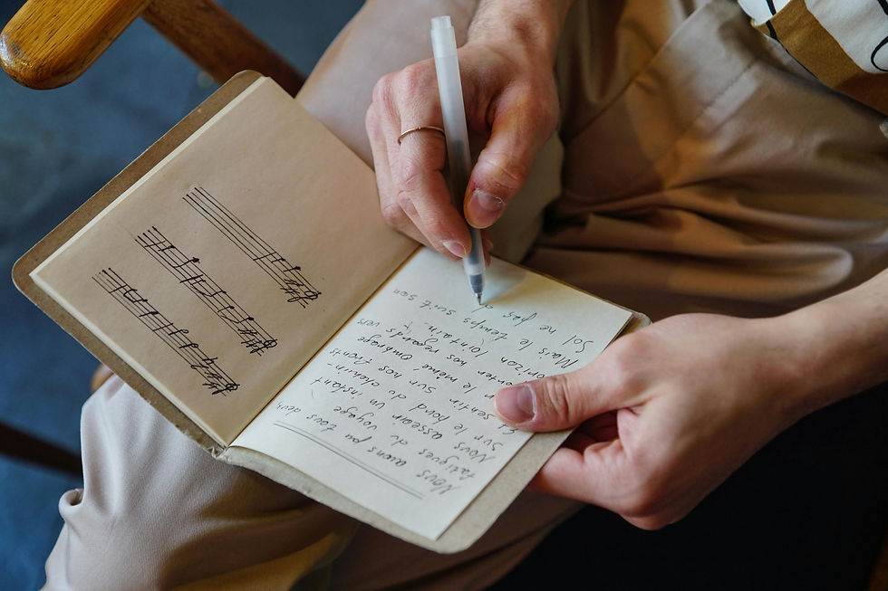 songwriter writing lyrics in a notebook